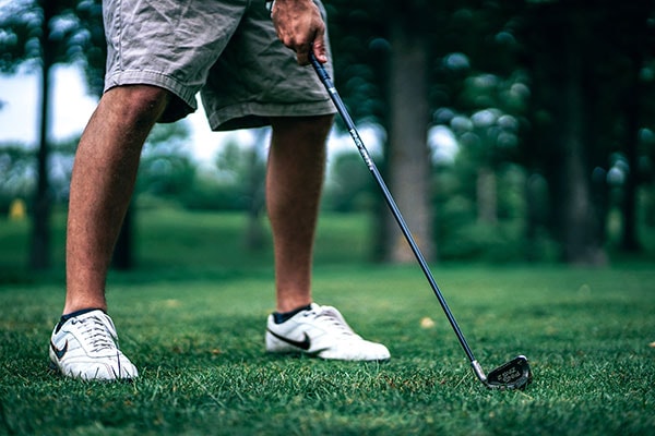 Golfer with iron ready to swing.