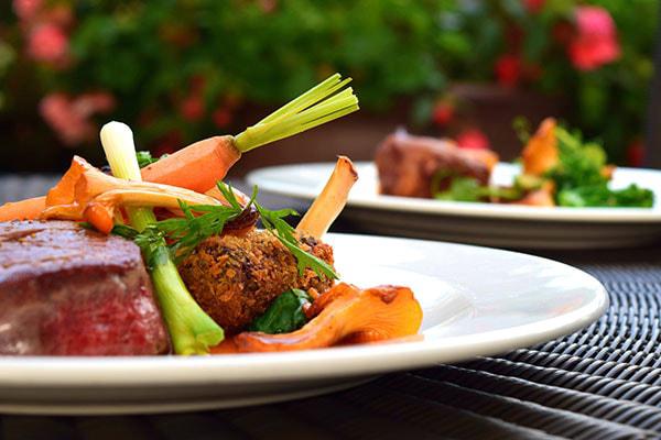 Plate of meat and vegetables on a table.